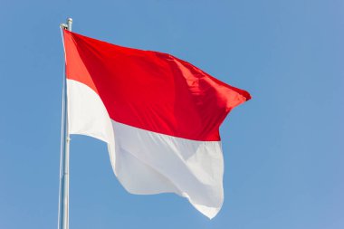 Endonezya ulusal bayrağı mavi gökyüzü arkaplanıyla dalgalanıyor 