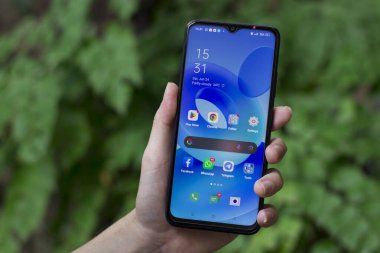Surakarta - Endonezya, 11 Ekim 2024: Oppo A17K android telefonlu erkek el ana ekranda sosyal medya simgesi