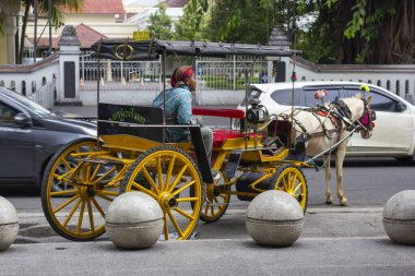 Yogyakarta - Endonezya, 4 Mayıs 2025: Andong veya Dokar bazı yerlerde Delman adı verilen insanlar Yogyakarta 'da ve tabii ki tüm Java adasında geleneksel bir at arabasıdır.