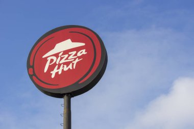Sukoharjo - Endonezya, 15 Ocak 2023: Pizza Hut işareti sabah mavi gökyüzü ile izole edilmiş