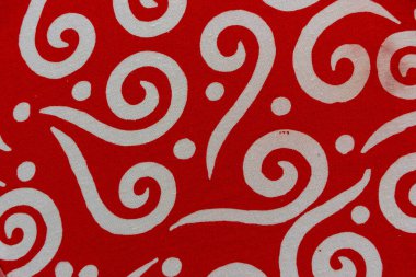Parlak kırmızı ve beyaz kıvrımlı dinamik kıvrımlı batik kumaş görüntüsü. Cesur, dalgalı çizgiler ve dağınık noktalar görsel olarak çarpıcı ve enerjik bir tekstil tasarımı yaratır..