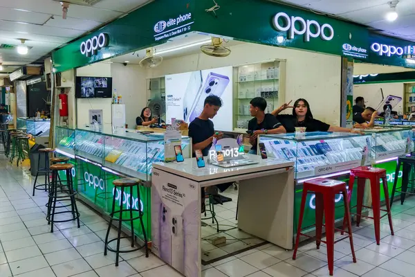 Surakarta - Endonezya, 24 Mayıs 2025: Hareketli bir OPPO cep telefonu mağazası, muhtemelen kalabalık bir pazar veya alışveriş merkezinde, birden fazla personel ve müşteri ile birlikte.