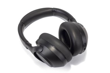 Mat siyah kulaklık görüntüsü var. Kulaklıklar hafif bir açıyla yerleştirilmiş. Pofuduk kulaklıklar, ayarlanabilir saç bandı ve genel olarak modern tasarım..