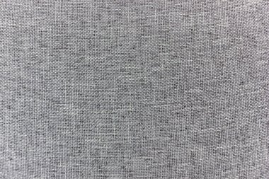 Yakın çekim gri bir kumaşın dokuma dokusunu yakalar. Malzeme birbirine kenetlenmiş ince ama dokunulabilir bir yüzey oluşturan ince ve tutarlı bir desen sergiliyor..