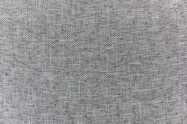 Yakın çekim gri bir kumaşın dokuma dokusunu yakalar. Malzeme birbirine kenetlenmiş ince ama dokunulabilir bir yüzey oluşturan ince ve tutarlı bir desen sergiliyor..