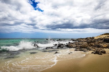 Deniz dalgaları ve mavi gökyüzü olan güzel sahil