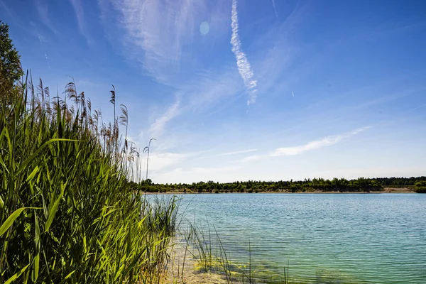 Güneş ve göl, gökyüzü güneşli bir yaz gününde göletin güzel bir manzarası.