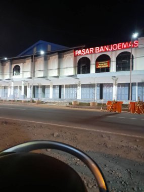 Night photo. The exterior view of the front of Banjoemas Market is a traditional market. Low angle view and no people.