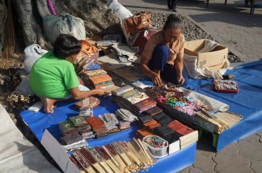 A group of old women selling knick-knacks or souvenirs in a parking lot at a tourist spot in Yogyakarta, Indonesia