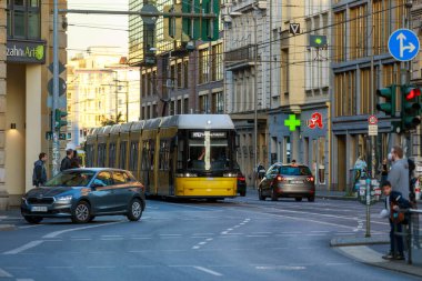 Berlin, Almanya - 7 Ekim 2022: Sarı tramvay cadde boyunca ilerliyor. Berlin tramvayı (Almanca: Strassenbahn Berlin), Almanya 'nın başkenti Berlin' de bulunan tramvay sistemidir..