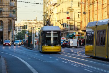 Berlin, Almanya - 7 Ekim 2022: Sarı tramvay cadde boyunca ilerliyor. Berlin tramvayı (Almanca: Strassenbahn Berlin), Almanya 'nın başkenti Berlin' de bulunan tramvay sistemidir..