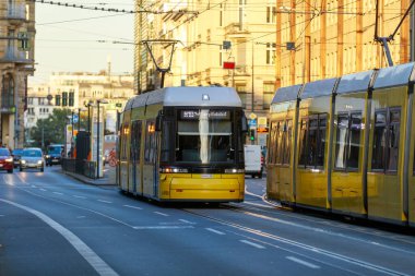 Berlin, Almanya - 7 Ekim 2022: Sarı tramvay cadde boyunca ilerliyor. Berlin tramvayı (Almanca: Strassenbahn Berlin), Almanya 'nın başkenti Berlin' de bulunan tramvay sistemidir..