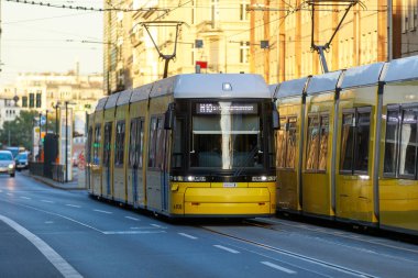 Berlin, Almanya - 7 Ekim 2022: Sarı tramvay cadde boyunca ilerliyor. Berlin tramvayı (Almanca: Strassenbahn Berlin), Almanya 'nın başkenti Berlin' de bulunan tramvay sistemidir..