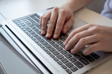 Bir adamın eli, dizüstü bilgisayarda dokunmatik ped kullanan bir iş adamı, dizüstü bilgisayarında yazarak çalışır..