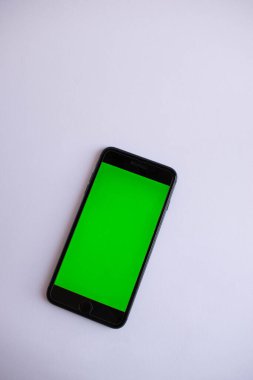 Yeşil ekranlı tanımlanamayan siyah akıllı telefon. Beyaz bir masaüstünde akıllı bir telefon. Yeşil ekranlı bir akıllı telefon. Kromakey kapaklı telefon.
