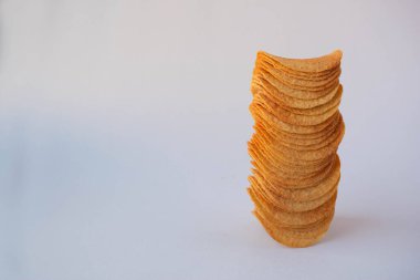 Beyaz arka planda izole edilmiş patates cipsi yığını.