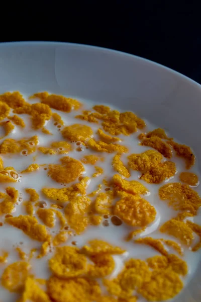 白いボウルにコーンフレーク ミルクと朝食のシリアル 暗い背景に隔離された — ストック写真