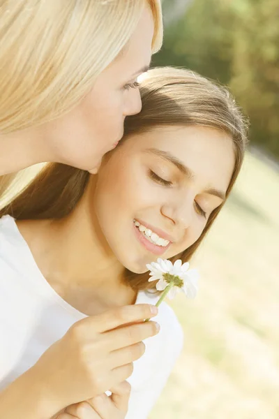 妈妈亲女儿妈妈吻女儿 抱着花 闻着花的特写 — 图库照片