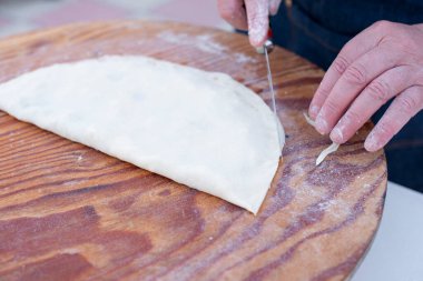 Yaşlı kadın yapımı, pide kesimi, hızlı, tahta tahtada toz haline getirilmiş sokak yemeği. Yemek pişirme kavramı.