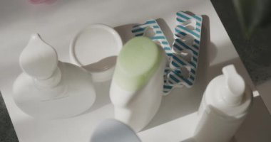 Pedikür, kaplıca salonundaki beyaz, temiz masaya ayarlandı. Banyo aksesuarları, cilt bakımı kozmetik ürünleri, ayak parmağı ayırıcılar ve traş makinesi, yavaş çekimde. Güzellik, cilt bakımı.