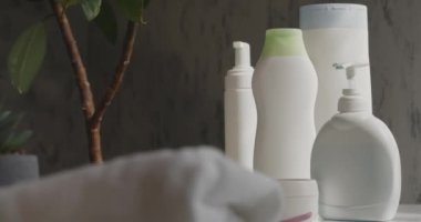 Banyo köpüğü, şampuan ve aksesuarlar banyo masasındaki beyaz plastik şişelerde. Otel spa 'sı için cilt ve saç bakımını kapat ya da hareket halinde olan ev banyosu hazırlığını. Sağlık, rahatlama prosedür kavramı.