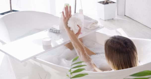在家里洗澡的时候 活动着用短的洗头胳膊放松的女人 从上面看匿名裸女洗澡 使用的托盘与浴室配件 自理的概念 — 图库视频影像