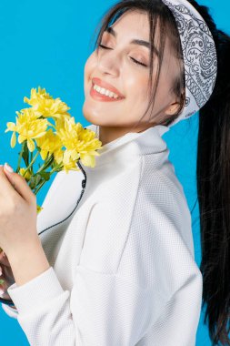 Güzel, at kuyruklu, sarı çiçekli, kapalı gözlerle kokan romantik bir kadın. Güzellik kavramı.