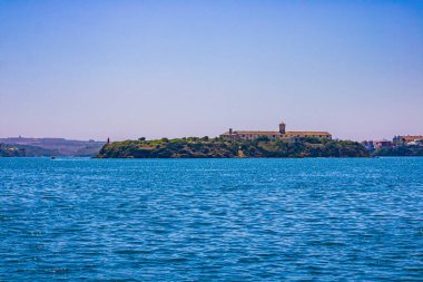 Deniz feneri olan eski bir kasabanın manzarası. Deniz, gökyüzü ve bulutlar.,
