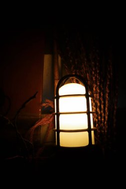 Karanlıkta duvardaki lamba çok güzel bir ışık yaydı..