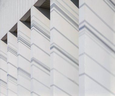 Beyaz arka plan duvarına yansıyan ışık ve gölgelerin minimalist fotoğrafçılığı görüntüyü benzersiz gösteren güzel ve doğal bir grafik deseni yaratır..