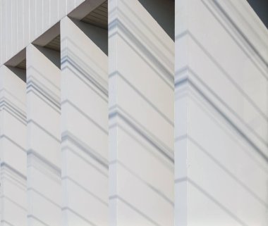 Beyaz arka plan duvarına yansıyan ışık ve gölgelerin minimalist fotoğrafçılığı görüntüyü benzersiz gösteren güzel ve doğal bir grafik deseni yaratır..