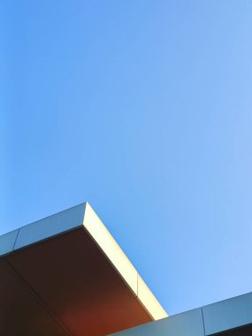 Dönüşümlü bina köşelerinin minimalist tarzı fotoğrafı fotoğrafa güzel ve benzersiz bir boyut kazandırıyor. Açık gökyüzü için boşluk ve metin eklemek için az bulut var.