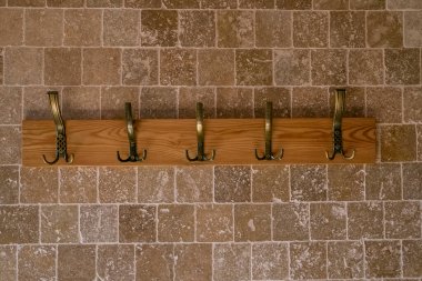 Ahşap askı. Duvara monte edilmiş tahta askı mermer kiremitlerle duvara sabitlenmiş..