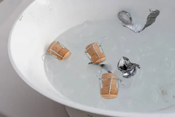 Şampanya mantarları buzlu suda. Şampanya şişesi tıkaçlarına yakın plan..