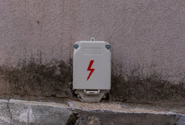 Tehlike işareti olan beyaz bir elektrikli kalkanın yakın çekimi. Yüksek voltajlı elektrik akım kalkanı.