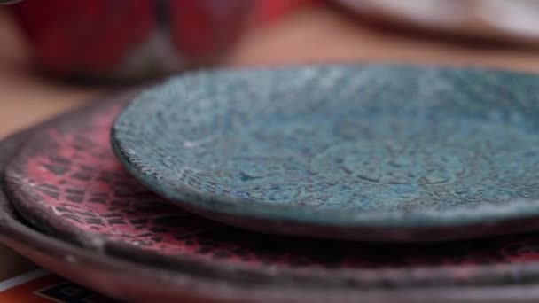 用手工制作的蓝色陶瓷盘的特写 女孩用手抚摩它 — 图库视频影像