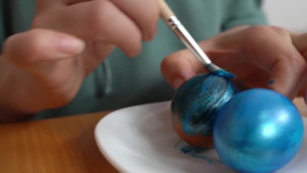 Una Joven Con Pincel Pinta Huevo Pollo Blanco Azul Plato — Vídeo de stock