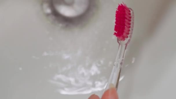 Een Close Knijpt Witte Tandpasta Roze Kop Van Tandenborstel Tegen — Stockvideo