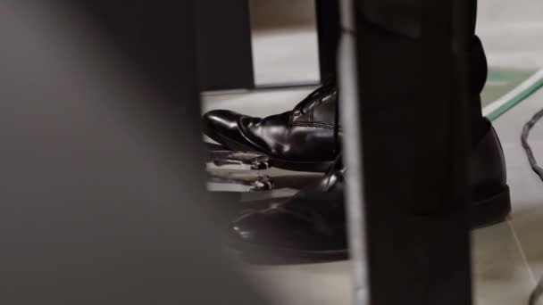 黒い革の靴をはいたピアニストが交響楽団のピアノペダルを支え続けている 閉じろ — ストック動画