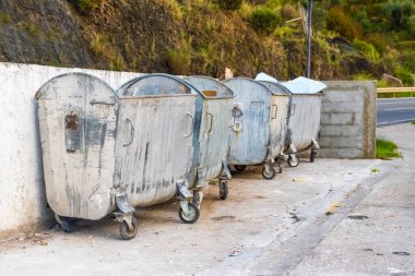 Şehirdeki yollardaki metal çöplükler her türlü çöple doludur. İnsan kirliliği. Atık ve atıkları yaralamak ve geri dönüştürmek için belirlenmiş alanlar.