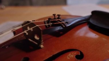 Keman masanın üstündeki nota kağıdında yatıyor. Kapat. String müzik enstrümanları ve sanat. Klasik müzik, müzik kültürü ve eğlence.