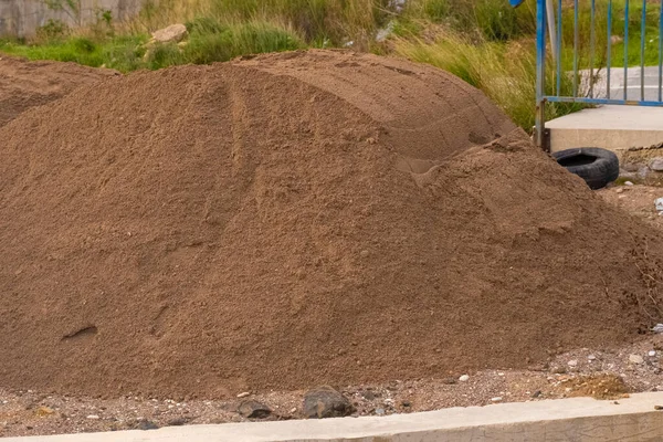 a large mountain of construction sand for the construction of the foundation of the building. A pile of dry construction sand. sand for building construction.