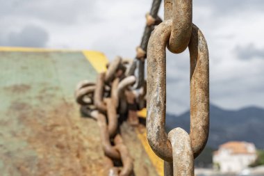 Metal zincirlere yakın, tuzlu sudan paslanmış, balıkçı teknesine bağlı, paslı metal zincirler..