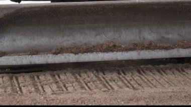 Kazı kovasının yakın çekimi kumsaldaki kumu dümdüz eder. Böylece büyük bir yapı inşa etmeye başlayabilirsiniz..