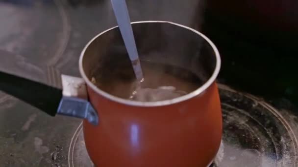 オレンジ タークで醸造されたクローズアップ ブラック アラビカ コーヒーは自宅の誘導ホブに立つ自家製ブラック コーヒー — ストック動画