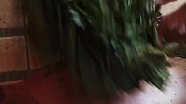 Sırtından Dövülen Bir Adamın Banyoda Ardıç Süpürgesiyle Dövüldüğü Yakın Plan — Stok video