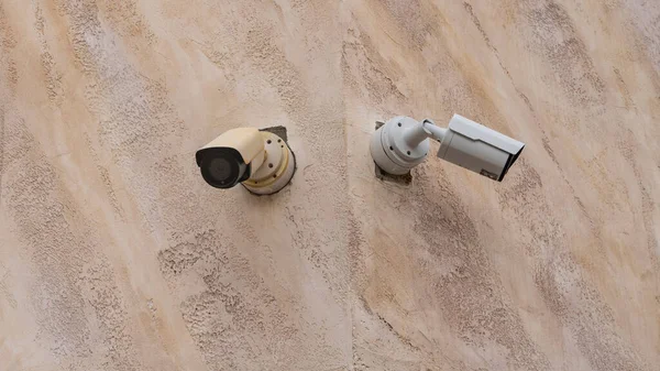 İki yan yana asılan CCTV kameraları, bina sakinlerinin güvenliği için binanın köşesine yerleştirildi..