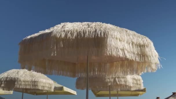 Plážový Deštník Měkké Slámy Rozvíjí Slabém Větru Modré Pórové Pláži — Stock video