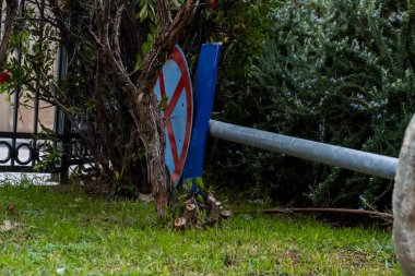 Yerde yatan bir yol tabelası sert bir rüzgardan dolayı park yasağının düştüğünü gösteriyor. Kazadan sonra yerde durmamızı yasaklayan bir işaret var. Trafik işaretleri trafiği düzenliyor.