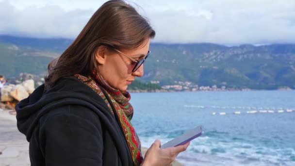 Close Girl Sunglasses Sea Sitting Her Phone Background Beach Water — Stock Video
